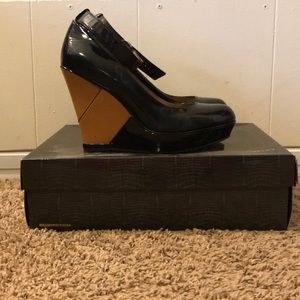 Black shoe with a tan wedge.